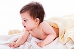 Infant Lying Under The Yellow Towel Stock Photo