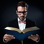 Intrigued Businessman With Glasses Reading A Book. Isolated On B Stock Photo