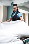 Lady Attendant Arranging Bed Sheet Stock Photo