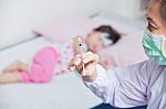 Lady Doctor Preparing An Injection For A Little Asian Girl Stock Photo