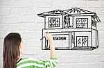 Lady Drawing House On Brick Wall Stock Photo