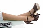 Legs putting On Desk With Keyboard Stock Photo
