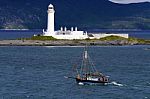 Lighthouse And Sailing Ship Stock Photo