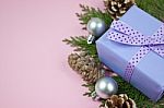 Lilac Gift With Polka Dot Ribbon With Christmas Decoration On Pink Background Stock Photo