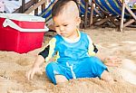Little Asian Boy Playing Sand On The Beach Stock Photo