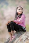 Little Asian Girl Sit On The Rock With Pink Sakura Stock Photo