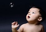 Little Baby Asian Boy Drooling And Looking Soap Bubble Stock Photo