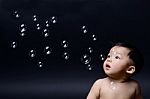 Little Baby Asian Boy Looking Soap Bubbles Stock Photo