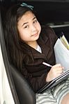 Little Business Girl Writing Something In Her Car Stock Photo
