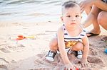 Little Cute Boy Playing Sand On The Beach Stock Photo