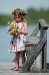 Little Girl With Flowers On A Bridge Stock Photo
