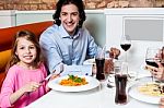 Little Girl With Her Father At A Restaurant Stock Photo