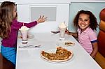 Little Girls Enjoying Pizza In A Restaurant Stock Photo