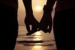 Love Couple Holding Finger At Sunset On The Beach Stock Photo