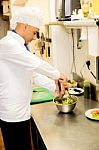 Male Chef Busy In Giving Final Touch To Recipe Stock Photo