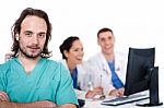 Male Doctor On Focus, Two Doctors Discussing At Background Stock Photo