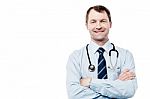 Male Doctor Smiling With Arms Crossed Stock Photo