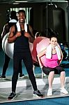 Man And Woman Exercising In Gym Stock Photo
