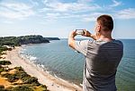 Man In A Gray T-shirt Photographing Seascape Stock Photo
