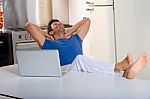 Man In Kitchen With Laptop Stock Photo