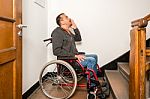 Man In Wheelchair Facing A Barrier Of Stairs Stock Photo