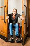 Man In Wheelchair Stuck Between Swing Doors Stock Photo