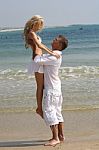 Man lifting her lover at beach Stock Photo