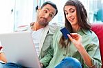 Man Looking At Woman With Laptop And Credit Card Stock Photo