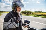 Man Motorcyclist In Protective Helmet Looking At Smartphone Disp Stock Photo