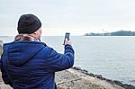 Man Photographing Seascape By Mobile Phone Stock Photo