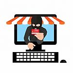 Man Wearing Balaclava And Holding Credit Card While Using Laptop At Desk Stock Photo
