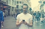 Man With Cell Phone Walking On Street Stock Photo