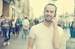 Man With Mobile Phone Walking On Street Stock Photo