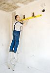 Man Worker Checks The Wall With A Level Stock Photo