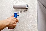 Man's Hand Smoothing The Wallpaper With A Roller Closeup Stock Photo