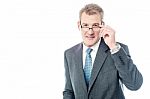 Mature Businessman Holding Eye Wear Stock Photo