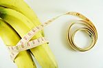 Measuring Tape Wrapped Around Bananas. Concept Of Diet Stock Photo