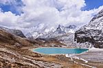 Milk Lake On The Snow Mountains With Clouds And Sky In Yading, China Stock Photo