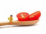 Miniature Woman Sitting On Fresh Grape Or Cherry Tomato With Woo Stock Photo