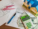 Modelhouse, Calculator And Us Dollars On Construction Planning Stock Photo