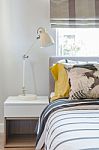 Modern Bedroom With White Lamp On White Wooden Table Side Stock Photo
