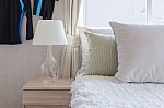 Modern Glass Lamp On Wooden Side Table In Bedroom Stock Photo
