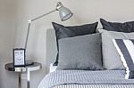 Modern Grey Lamp With Alarm Clock On Side Table In Bedroom Stock Photo