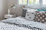 Modern Lamp On Bedside Table With Wooden Bed Stock Photo