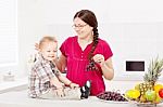 Mother And Son With Fruits In The Kitchen Stock Photo