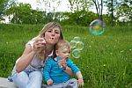 Mother With Her Son Blow Bubbles Stock Photo