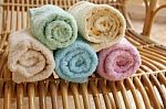 Multicolour Towels Rolls On Wood Chair Stock Photo
