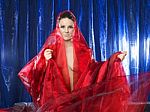 Mystic And Beautiful Young Woman In Red Silk On Blue Background Stock Photo
