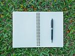 Notebook And Pen On Lawn Stock Photo