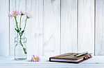 Notebook And Pen With Flower On White Wooden Table Stock Photo